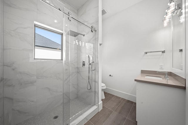 bathroom with toilet, vanity, and a shower with shower door