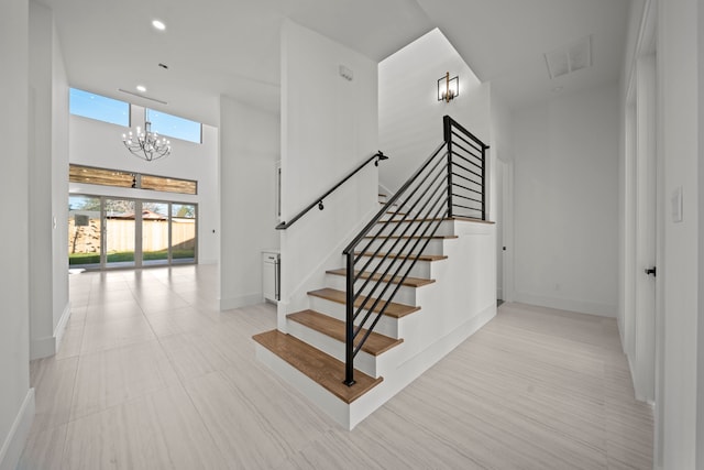 stairs featuring a chandelier