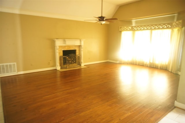 unfurnished living room featuring a high end fireplace, ceiling fan, crown molding, wood-type flooring, and lofted ceiling