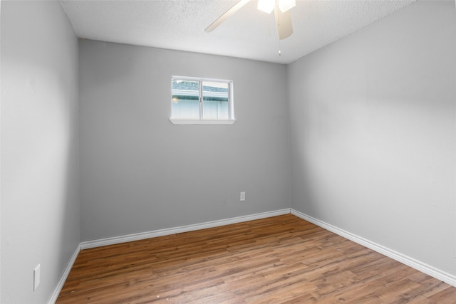 unfurnished room featuring hardwood / wood-style flooring, ceiling fan, and a textured ceiling