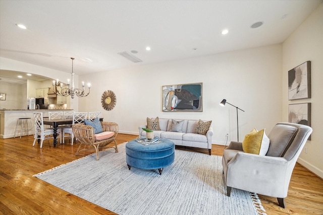 living room with a chandelier and light wood-type flooring