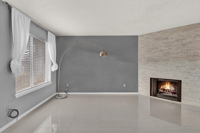 unfurnished living room featuring plenty of natural light, light tile patterned floors, and a textured ceiling