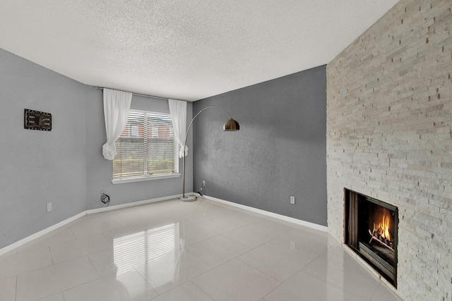 unfurnished living room with a fireplace, light tile patterned floors, and a textured ceiling