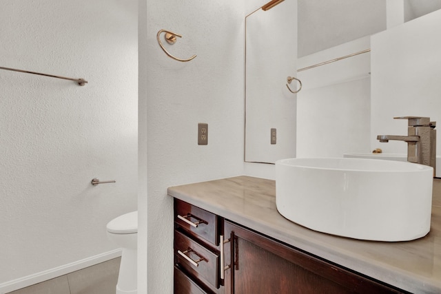 bathroom with tile patterned flooring, vanity, and toilet