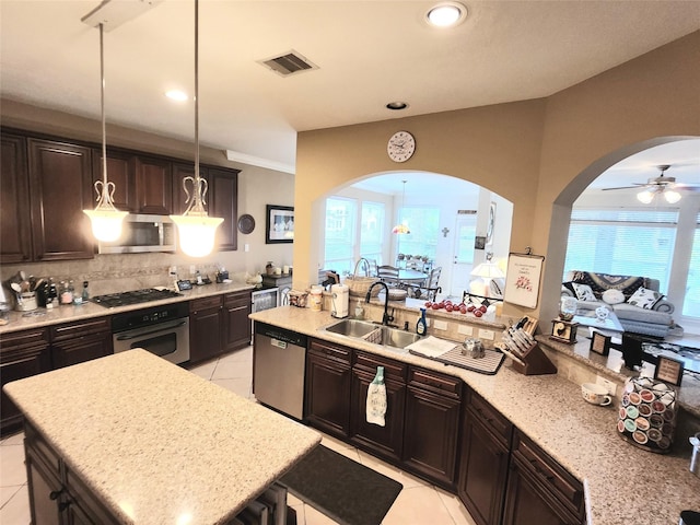 kitchen with sink, decorative light fixtures, a kitchen island with sink, light tile patterned flooring, and appliances with stainless steel finishes