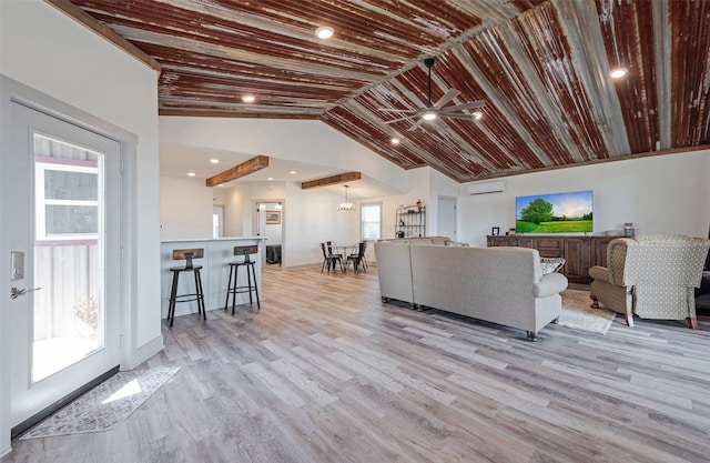 living room featuring ceiling fan, a healthy amount of sunlight, light hardwood / wood-style floors, and vaulted ceiling