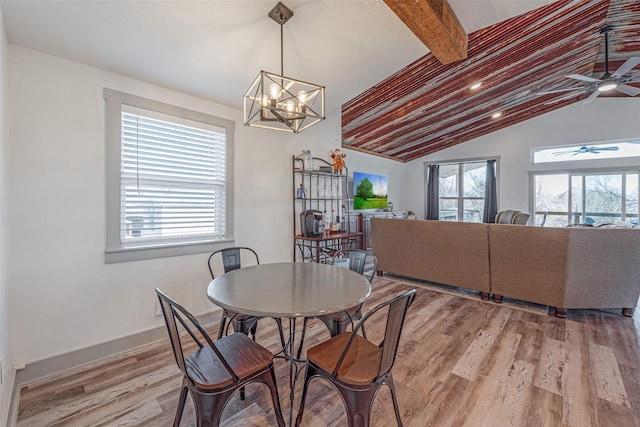 dining area with hardwood / wood-style floors, lofted ceiling with beams, and ceiling fan with notable chandelier