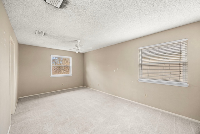 carpeted empty room with a textured ceiling and ceiling fan