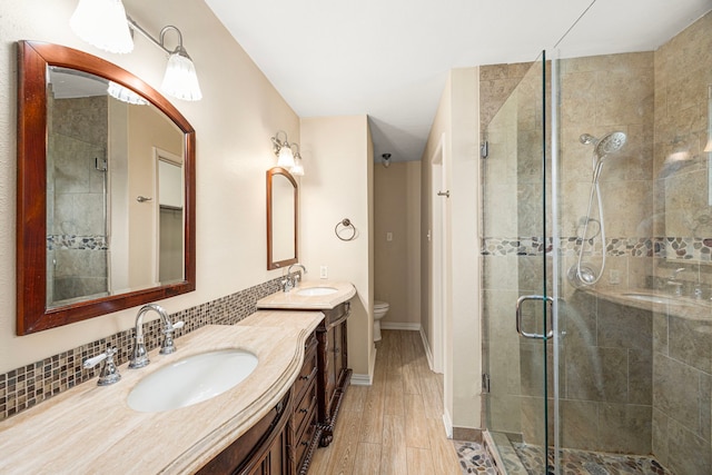 bathroom with toilet, an enclosed shower, tasteful backsplash, vanity, and hardwood / wood-style floors