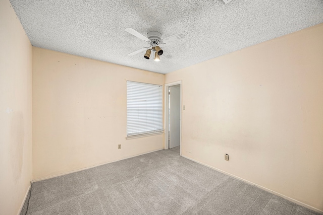 unfurnished room with ceiling fan, light carpet, and a textured ceiling