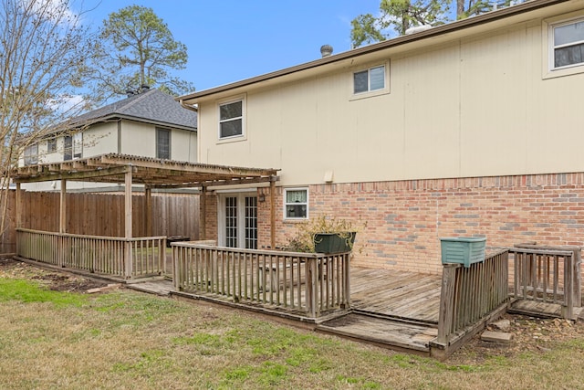 rear view of property with a wooden deck, a pergola, a lawn, and french doors