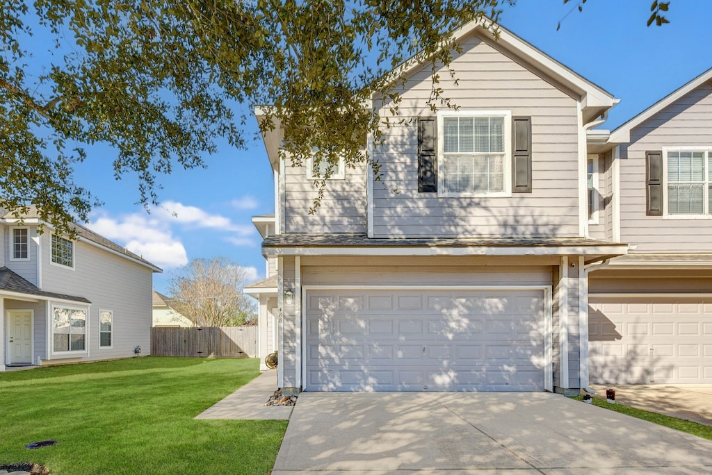 view of property featuring a front yard and a garage