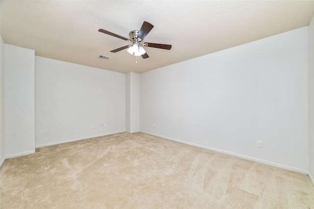 carpeted spare room with a textured ceiling and ceiling fan