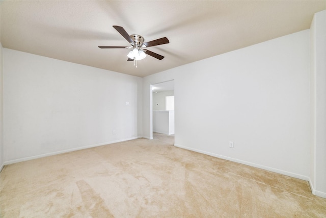 spare room with ceiling fan and light colored carpet