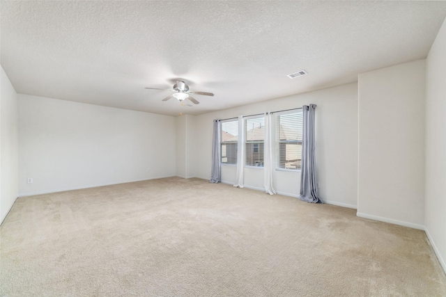 carpeted empty room featuring ceiling fan and a textured ceiling