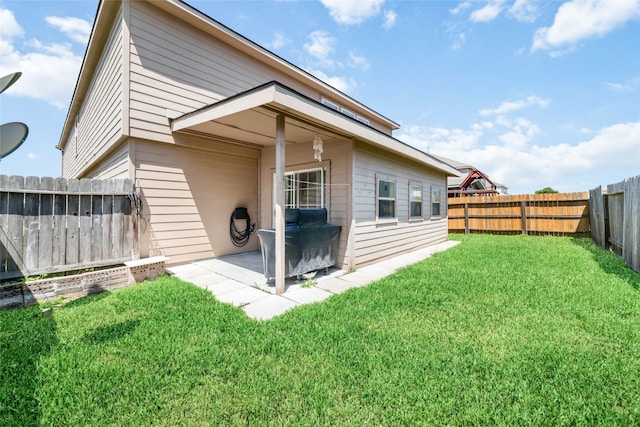 rear view of property featuring a yard and a patio