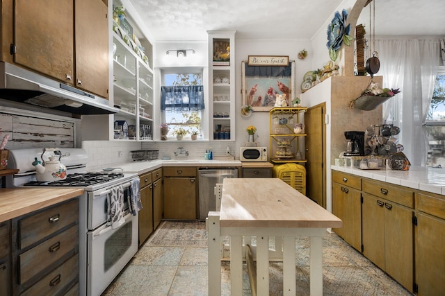 kitchen with pendant lighting, white appliances, crown molding, and backsplash