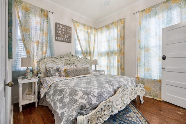 bedroom with dark hardwood / wood-style flooring, ceiling fan, and ornamental molding