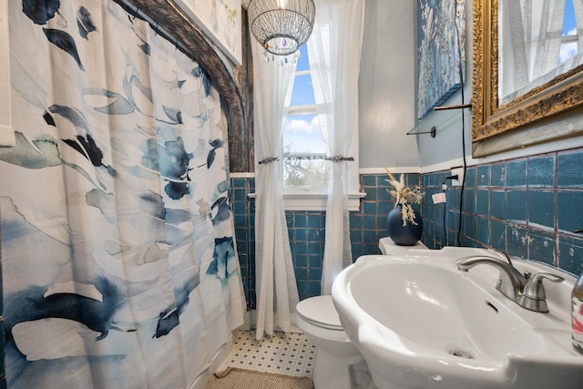 bathroom featuring tile patterned floors, sink, tile walls, toilet, and curtained shower