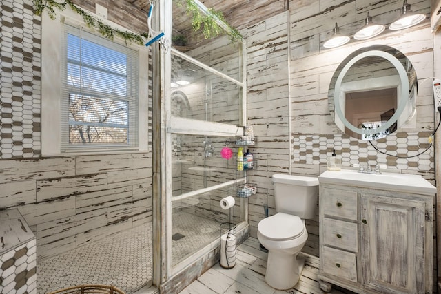 bathroom with a shower with door, vanity, and toilet