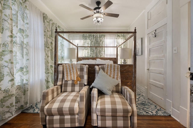 living area featuring dark wood-type flooring, ceiling fan, and ornamental molding