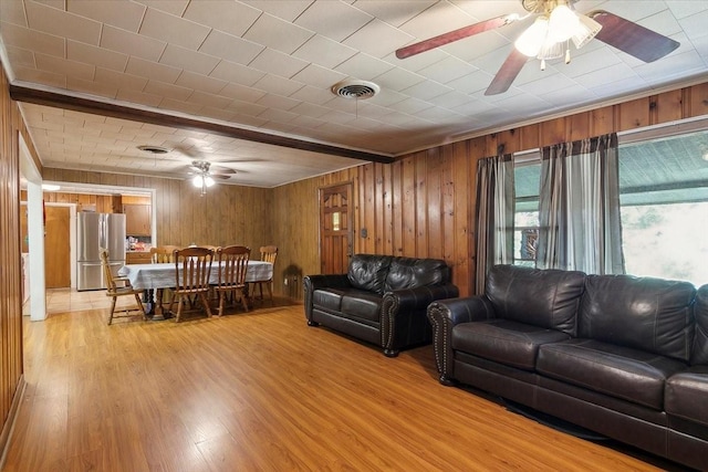 living room with wood walls and light hardwood / wood-style flooring