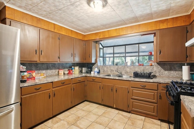 kitchen featuring gas stove, sink, backsplash, stainless steel fridge, and ornamental molding