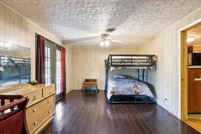 bedroom with dark hardwood / wood-style flooring, refrigerator, and ceiling fan