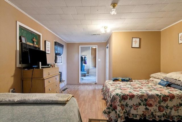 bedroom featuring light wood-type flooring and ornamental molding