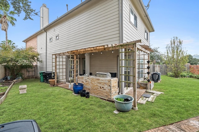 rear view of property with area for grilling and a yard