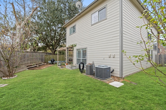 back of property with a yard and central air condition unit