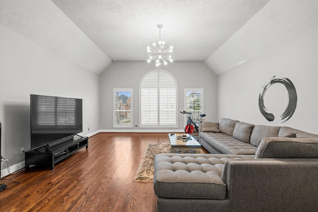 living room with a textured ceiling, hardwood / wood-style flooring, an inviting chandelier, and lofted ceiling