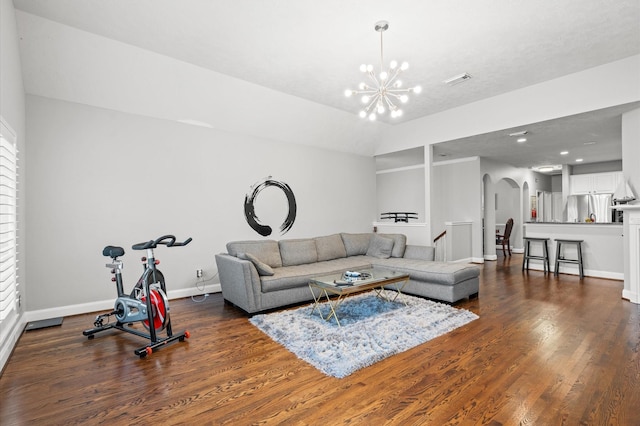 living room with dark hardwood / wood-style flooring and an inviting chandelier