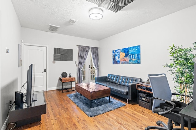 living room featuring hardwood / wood-style floors and a textured ceiling