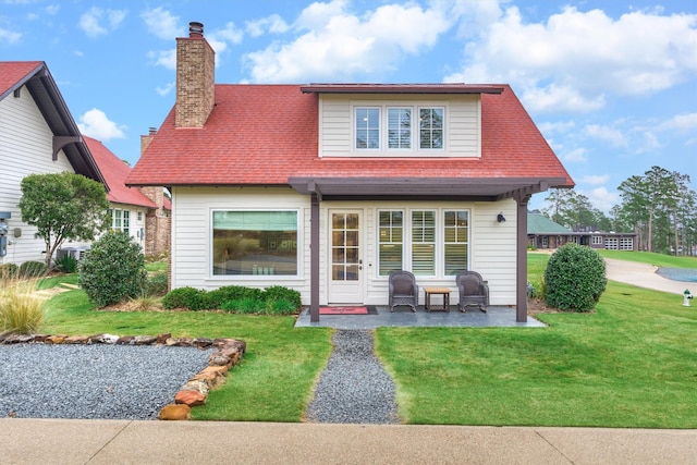 back of property with a patio area and a yard