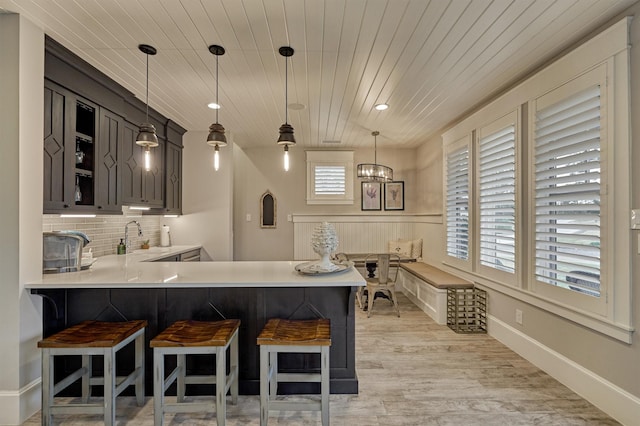 bar featuring gray cabinetry, sink, wooden ceiling, and hanging light fixtures