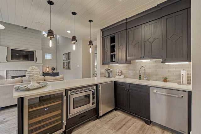 kitchen with wooden ceiling, sink, light wood-type flooring, appliances with stainless steel finishes, and decorative light fixtures