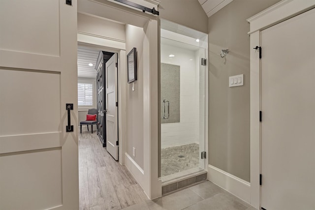 interior space with wood-type flooring, walk in shower, and lofted ceiling