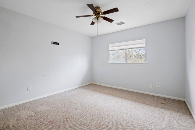 carpeted spare room featuring ceiling fan