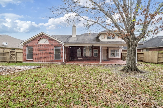 rear view of property with a lawn and a patio