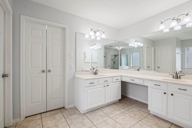 bathroom with tile patterned flooring, vanity, and an enclosed shower