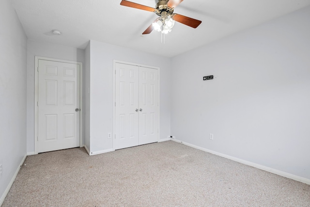 unfurnished bedroom with a closet, light colored carpet, and ceiling fan