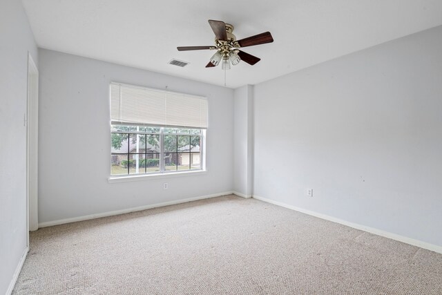 carpeted spare room featuring ceiling fan