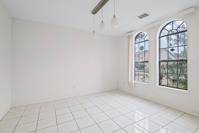 tiled empty room featuring plenty of natural light