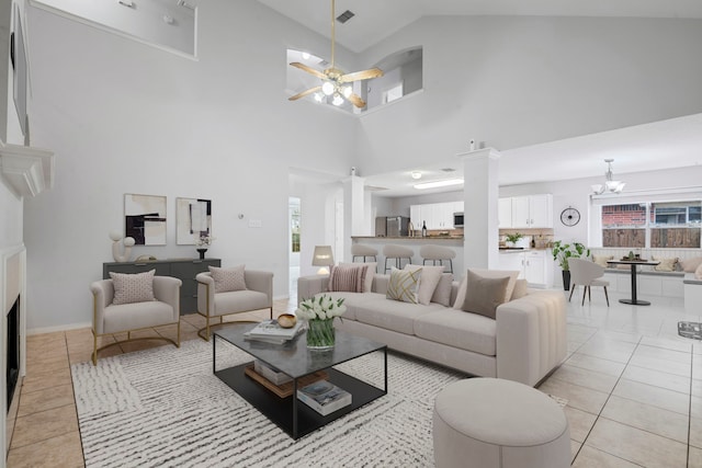 living room with ceiling fan with notable chandelier, high vaulted ceiling, and light tile patterned floors