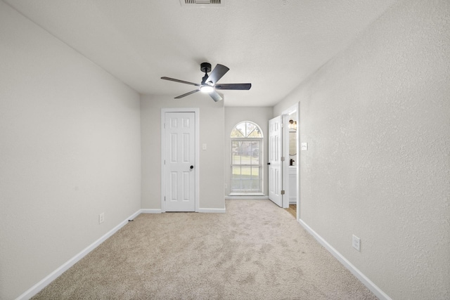 spare room featuring light colored carpet and ceiling fan