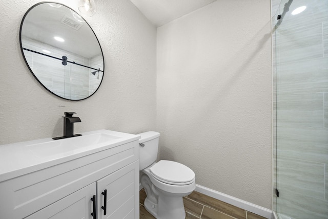 bathroom with vanity, an enclosed shower, and toilet