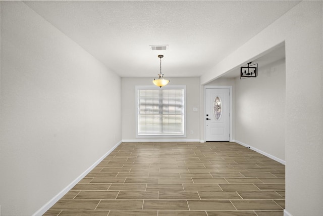 foyer entrance with a textured ceiling