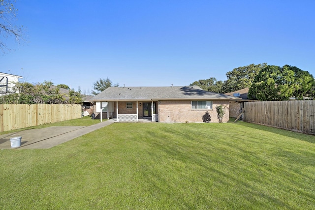 back of house with a lawn and a carport