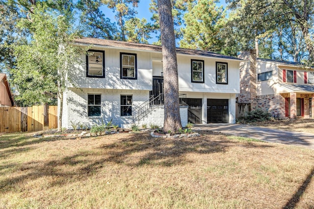 raised ranch featuring a front yard and a garage